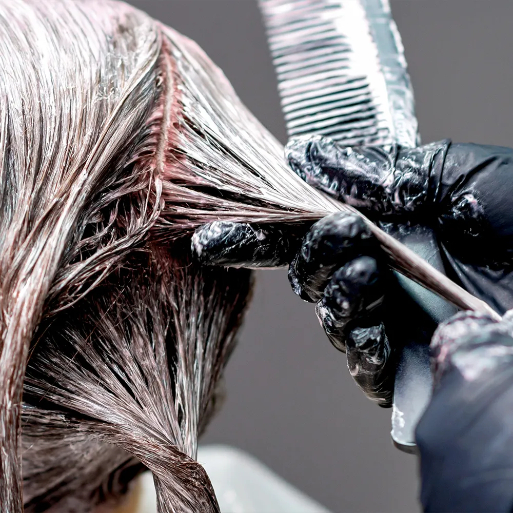 Friseurenhände während Haarcoloration in Nahaufnahme
